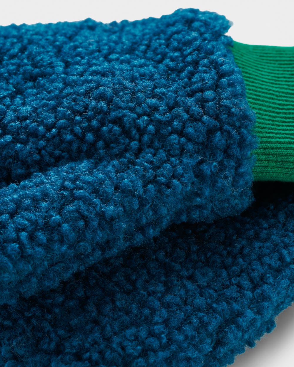 Blue borg mittens with contrasting green cuff made from recycled materials. 